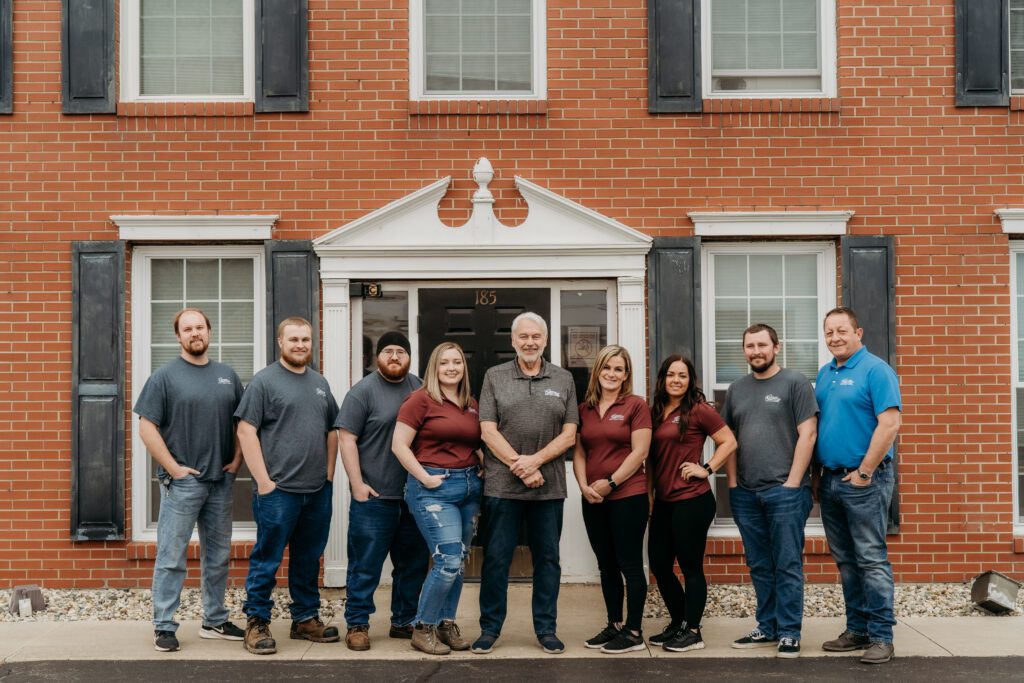 Midwest Integrated Solutions Team Members Standing as A Group In Front of a big brick building